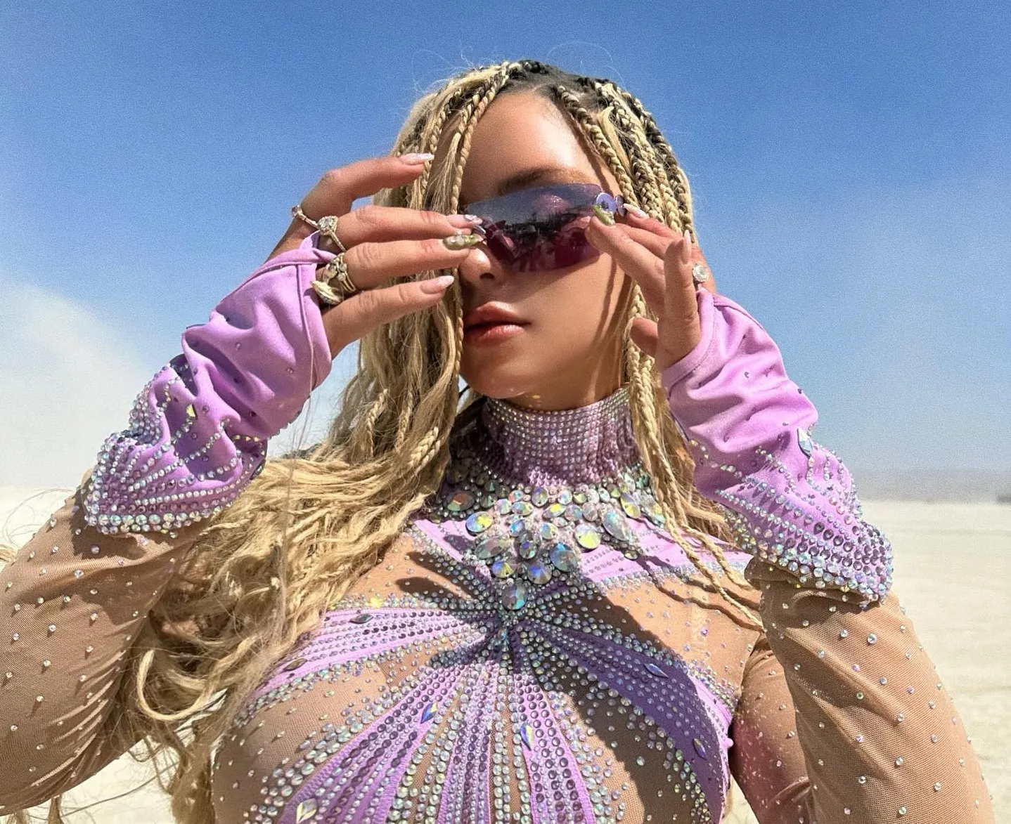 Wearing a bodysuit with decorations Demi Rose rides a bicycle in the middle of the desert - Gossibox.com