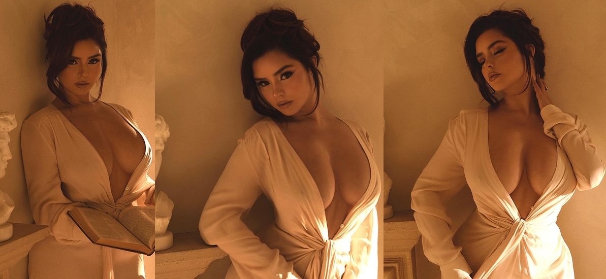 Demi Rose shows off her attributes by posing with her robe open and reading a book