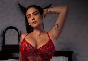 Celia Lora turns her back to the camera and exposes her rear in red floss lingerie